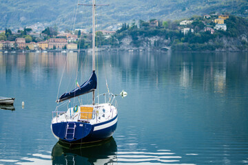 Colourful yacht docked at marina of Lecco town on spring day. Picturesque waterfront of Lecco...