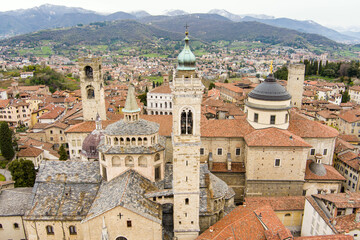 Fototapeta premium Scenic aerial view of Bergamo city. Flying over Citta Alta, town's upper district, known by cobblestone streets and encircled by Venetian walls. Bergamo, Lombardy, Italy.