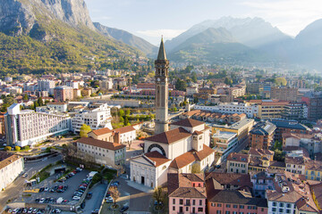 Fototapeta na wymiar Sunny aerial cityscape of Lecco town on spring morning. Picturesque waterfront of Lecco town located between famous Lake Como and scenic Bergamo Alps mountains.