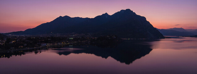 Stunning aerial cityscape of Lecco town on spring evening. Picturesque waterfront of Lecco town located between famous Lake Como and scenic Bergamo Alps mountains.