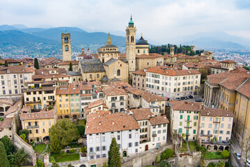 Scenic aerial view of Bergamo city. Flying over Citta Alta, town's upper district, known by cobblestone streets and encircled by Venetian walls. Bergamo, Lombardy, Italy.