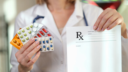 Pharmacist is holding prescription paper and lot of medical pills in her hands close-up.