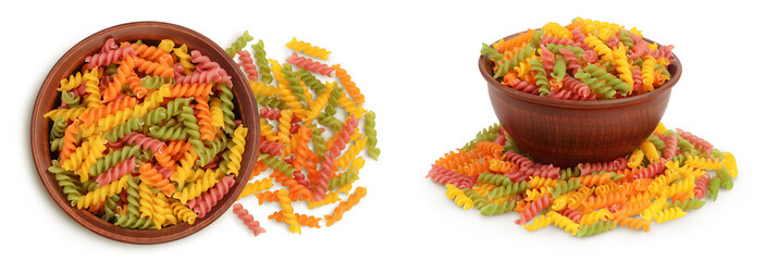 raw Fusilli colored pasta in ceramic bowl isolated on white background with full depth of field. Top view. Flat lay