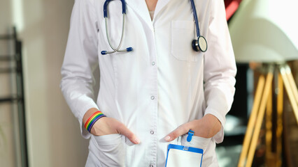 Cropped image of nurse with rainbow bracelet on her hand.
