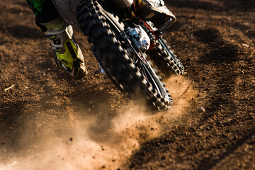 A young man, a man, an athlete, driving a motocross motorcycle in the blur, on a dirt track....