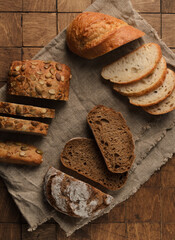 Different Types of Bread on the wood background. Variety of delicious bread in a bakery. Flat lay, top view