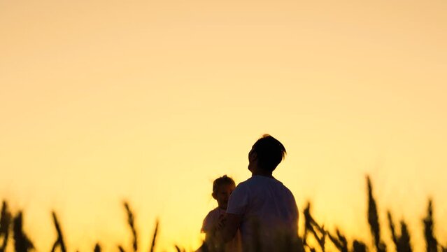 Dad plays with his daughter, throws up child with his hands in sky, outdoors, Silhouette. Family game concept. Childish, superhero, fly. Happy Father, child, little girl have fun together, park sun