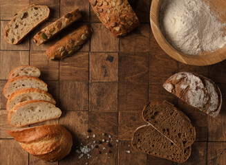Different Types of Bread with seeds and spices on the wood background. Variety of delicious bread...