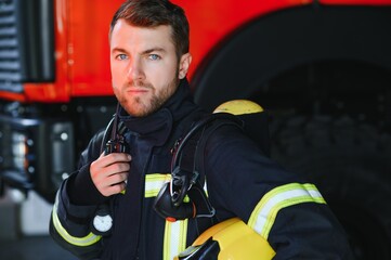 Photo of fireman with gas mask and helmet near fire engine