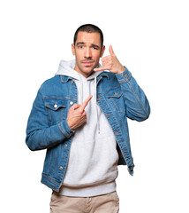 Hesitant young man making a gesture of calling with the hand
