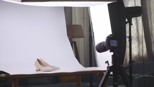 The Camera In Front Of Women'S Shoes On White Background After Being Used By Someone To Taking Photos In Home Studio 
