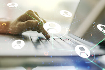 Double exposure of social network icons concept with hand typing on computer keyboard on background. Networking concept