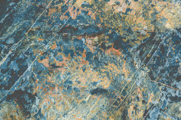 Abstract rock formation background that contains interesting dark blue and yellow orange colors and some grapes on the surface