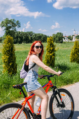 Obraz premium Young woman in the city rides bike and leads an active lifestyle doing sports