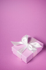 Pink gift box with a white ribbon