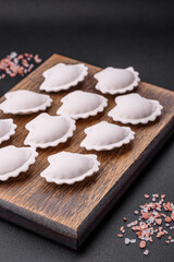 Raw frozen stuffed dumplings on a wooden cutting board