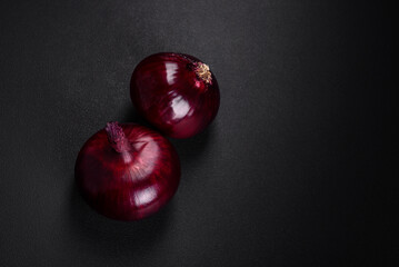 Fresh raw red onion on dark textured concrete background