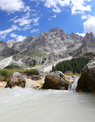 Alpine landscape and the stream with icy water that comes from the mountains