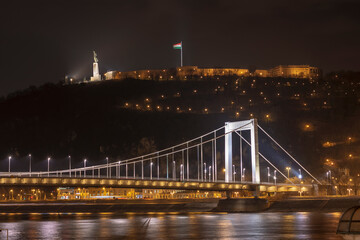Fototapeta na wymiar Illuminated Elizabeth bridge over Danube river with Gellert hill and Citadella Liberty Statue at night, Budapest, Hungary 