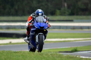 Motorcycle rider riding at high speed on his blue sport motorcycle. 