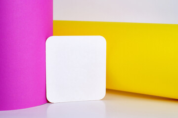 Fototapeta premium Blank white card isolated on pink and yellow background. Place for text. Mock up greeting card. Form 