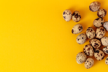 Quail eggs lays on yellow paper background with copy space or empty place for text. Easter holiday. Visiting card. Religious layout. Springtime design. Healthy food product. Farm organic production