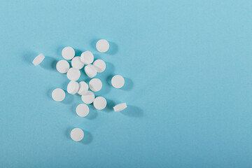 Herbal and Vitamin white pills healthy food freely laid on blue background