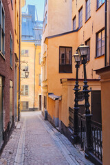 Obraz premium Narrow small streets and courtyards of old part of Swedish Stockholm: sunny February tourist day in capital of Scandinavia, Gamla Stan island.