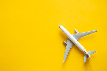 Airplane model on yellow background isolated, flat lay, air ticket, travel and vacation concept,...