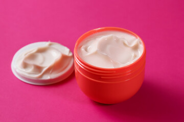 Delicate hand cream in a red container. Close-up of anti-aging cream