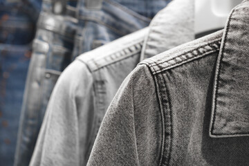 Collection modern jeans denim jacket hanging on hangers in the market close-up