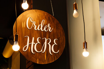 Restaurant service sign Order Here in modern loft style. Can be used in coffee shops, cafes, fast food restaurants.
