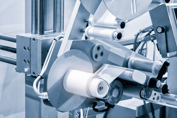 Fragment of the conveyor of sticking labeling machine. Abstract industrial background.