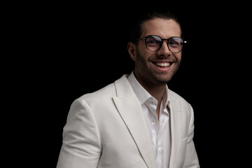 enthusiastic elegant man with glasses in white suit laughing