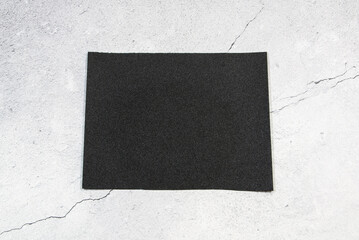 A piece of black emery on a cracked background.