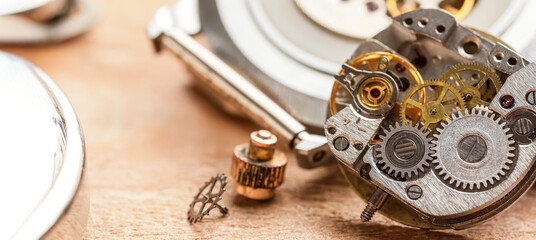 Broken watch on table of clockmaker, closeup