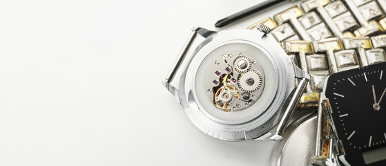 Broken wrist watches on light background with space for text, closeup