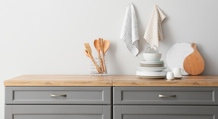 Set of clean dishes and utensils on table in kitchen