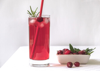Cranberry juice in a glass on a table with a white tablecloth