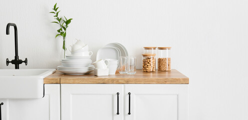 Set of clean tableware near sink on counter in kitchen