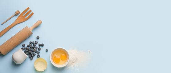 Ingredients for preparing bakery and utensils on light blue background with space for text