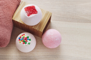 Different bath bombs on light wooden table