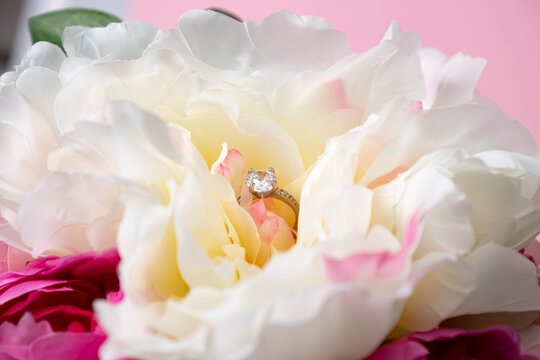 Wedding ring with a large diamond in peonies. Wedding jewelry composition.