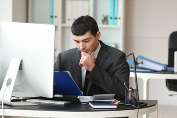 Obraz premium Young accountant working with document at table in office