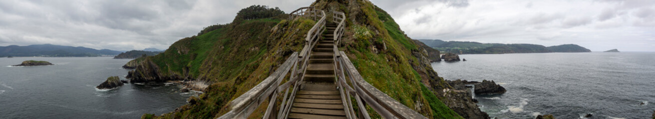 Fototapeta na wymiar Vistas panorámicas de las escaleras de madera en Vicedo, Lugo, en un lugar llamado Punta do Fuciño do Porco, en la costa gallega, verano de 2021, España.