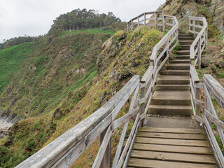 Fototapeta na wymiar Escaleras de madera en Vicedo, Lugo, en un lugar llamado Punta do Fuciño do Porco, en medio de la montaña, verano de 2021, España.
