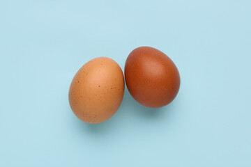 Unpeeled boiled eggs on blue background