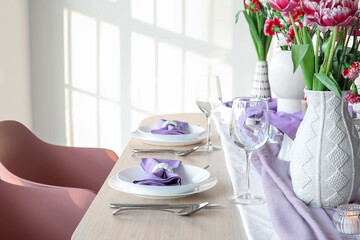 Beautiful table setting for International Women's Day celebration with carnation flowers in light room near window