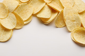 Frame made of delicious potato chips on white background