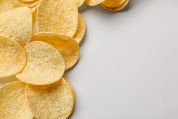 Frame made of delicious potato chips on white background